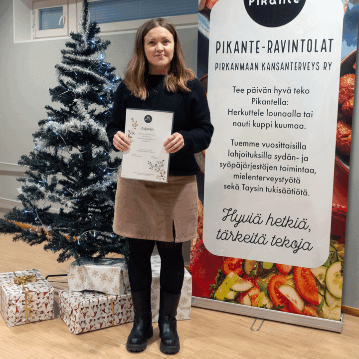 Laura Lahti Pikanten vuosijuhlassa, kädessään Lahjakirja