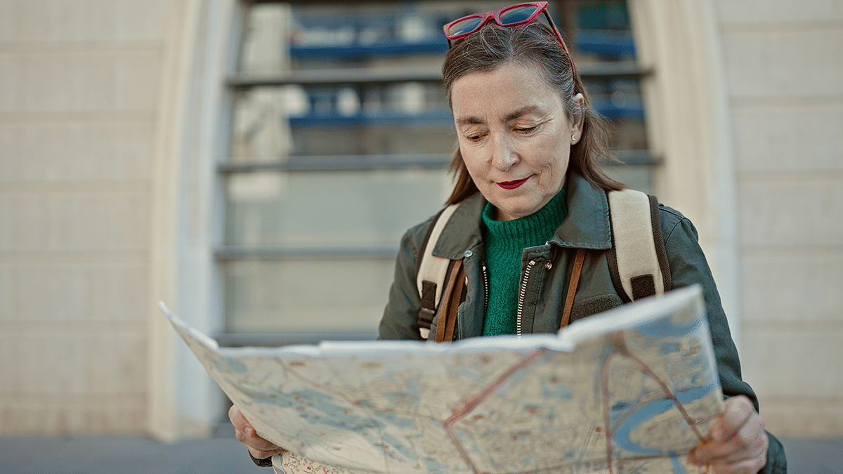 Henkilö tutkii paperista karttaa